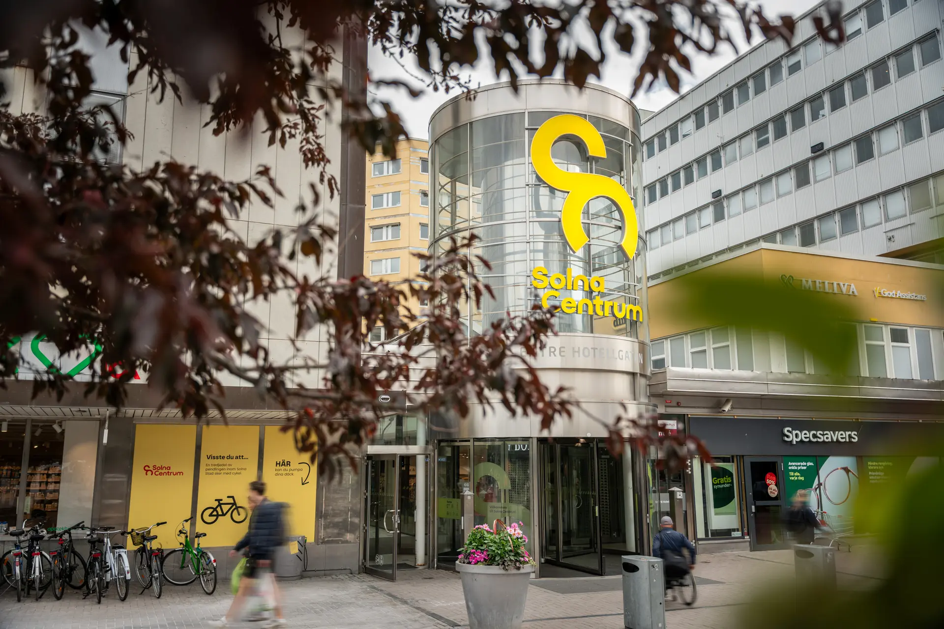 Entrén till Solna Centrum med cykelställ och butiker i närheten